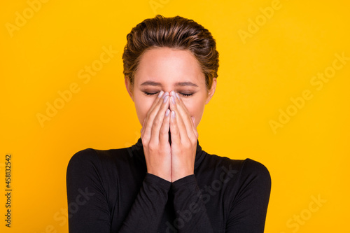 Portrait of attractive brown-haired dreamy girl closing mouth face isolated over bright yellow color background