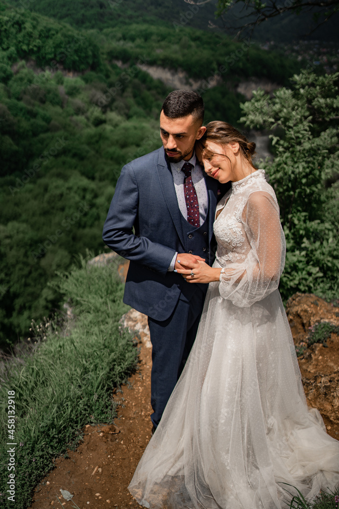 a beautiful hugging couple of newlyweds in a wedding ceremony in the mountains a beautiful hugging couple of newlyweds in a wedding ceremony in the mountains