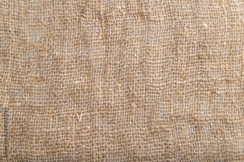Fragment of smooth brown linen tissue. Top view, natural textile background.