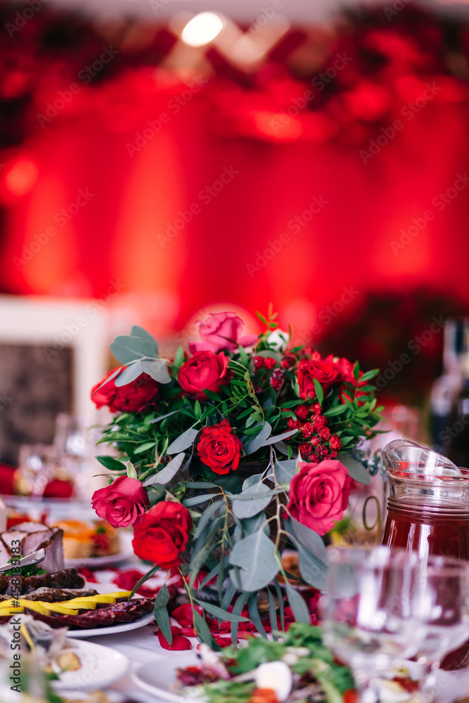 Wedding decorations. A beautifully decorated festive table with a beautiful floral arrangement of fresh flowers in a vintage vase