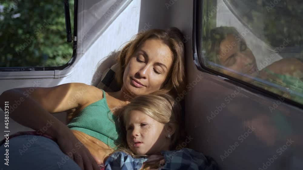 mom and daughter lie in a camper in the sun rays mom and daughter lie in a camper in the sun rays