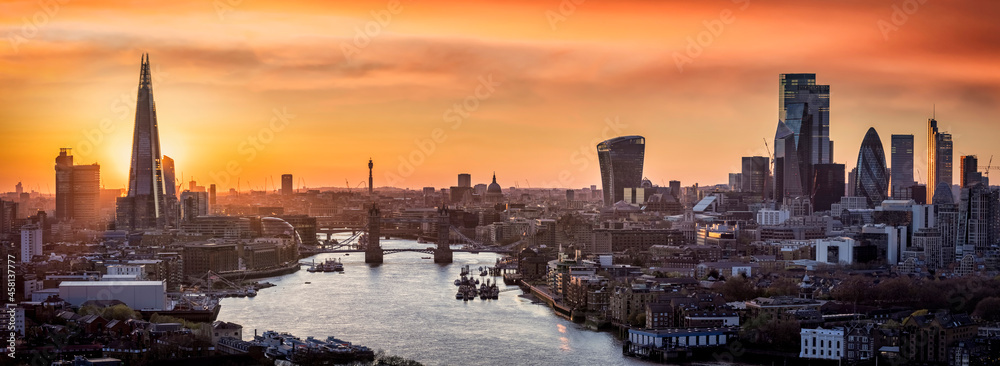 Golden sunset behind the modern skyline of London, with Tower Bridge, Thames river and City skyscrapers