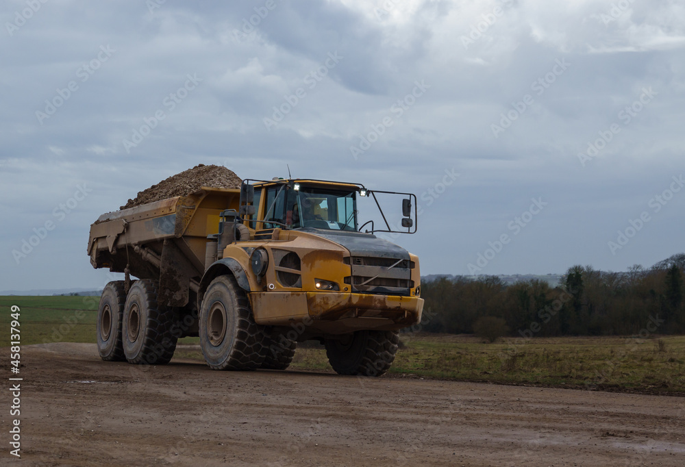 Obraz premium large yellow articulated dump truck earth mover truck in action Wiltshire UK 