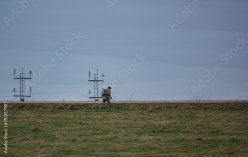 British army soldier completing an 8 mile tabbing exercise with fully loaded 25Kg bergen photo