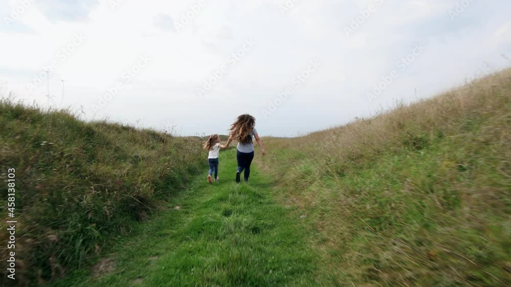 mother and child running holding hands on the grass mother and child running holding hands on the grass