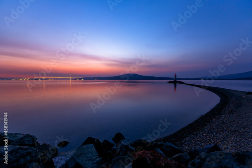 The Tokarevsky lighthouse in Vladivostok stands on a deserted spit. Bright sunrise in the sea capital of the Far East.