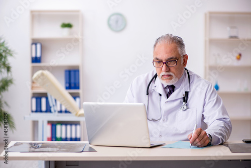 Old male doctor working at the hospital