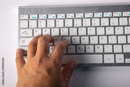 Close-up Man finger on white keyboard isolated on white background