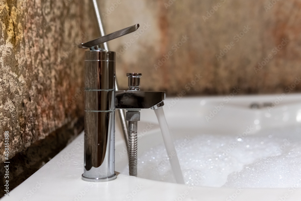 Jacuzzi, running water from a faucet and a filling Jacuzzi, a foamy water, natural stone walls and a vintage bathroom Jacuzzi, running water from a faucet and a filling Jacuzzi, a foamy water, natural stone walls and a vintage bathroom