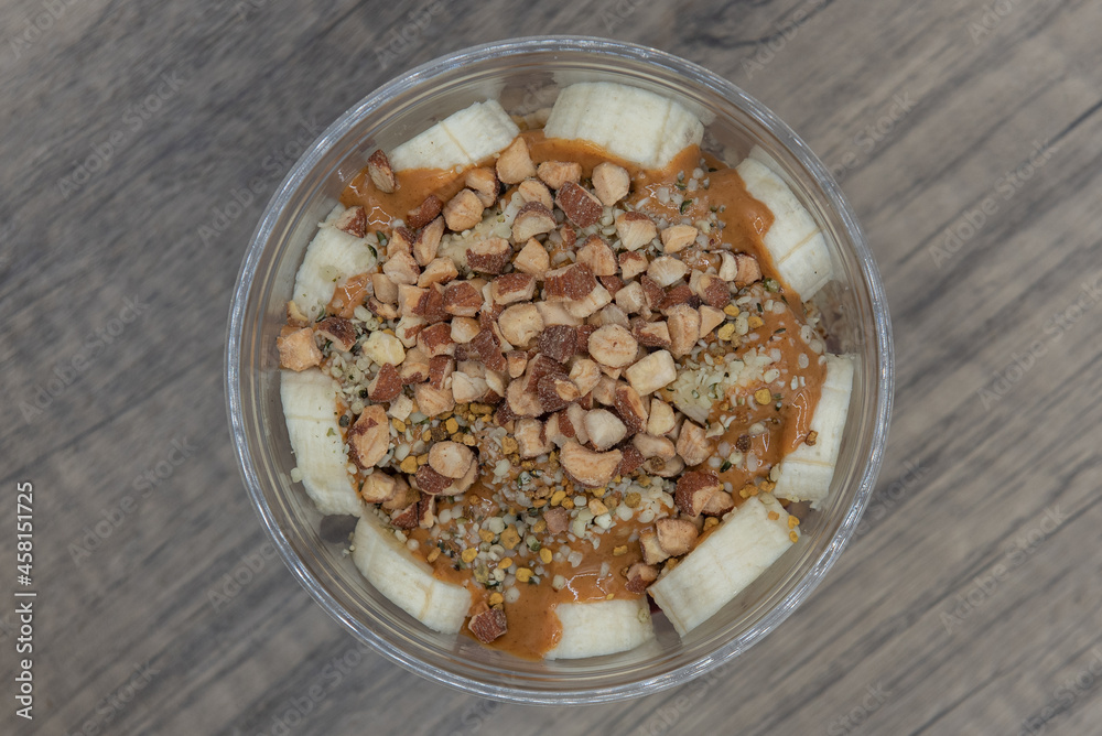 Overhead view of acai fruit bowl hemp seed, almonds, and peanut butter with blended flavors to increase your immunity and better nutrition Overhead view of acai fruit bowl hemp seed, almonds, and peanut butter with blended flavors to increase your immunity and better nutrition