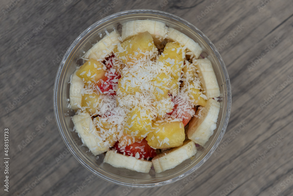 Overhead view of acai fruit bowl pineapple, coconut, and honey with blended flavors to increase your immunity and better nutrition