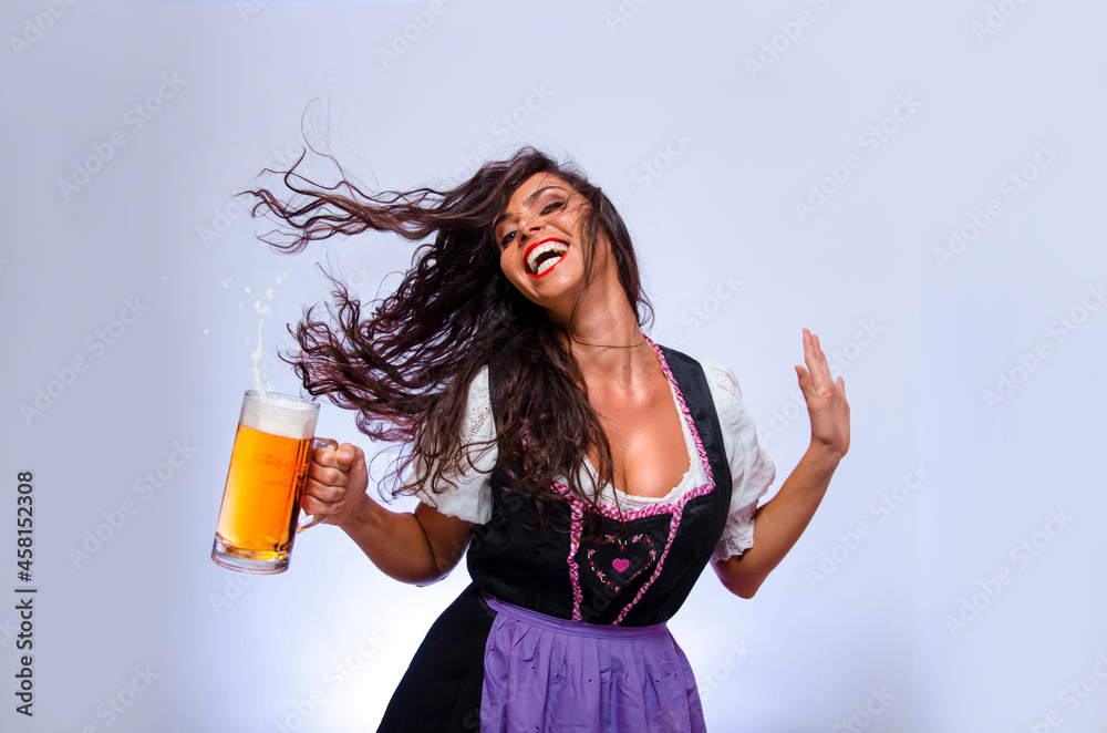 Attractive curly hair girl, hodling beer mug laughing, hair gflying, Oktoberfest concept Attractive curly hair girl, hodling beer mug laughing, hair gflying, Oktoberfest concept