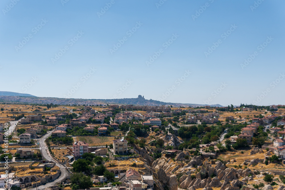 Cappadoci, a landscape photo taken from Uchisar castle, houses of the same structure and scattered but impressive architecture of the city, light blue sky and amazing landscape, travel to Turkey