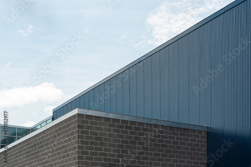 Fotografie The exterior wall of a commercial building with grey brick, light gray mortar, and silver color flashing or fascia