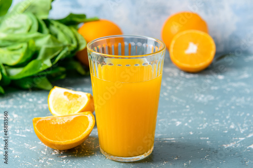 Glass with tasty orange juice on color background