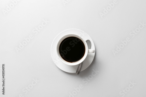 Cup of aromatic coffee on light background