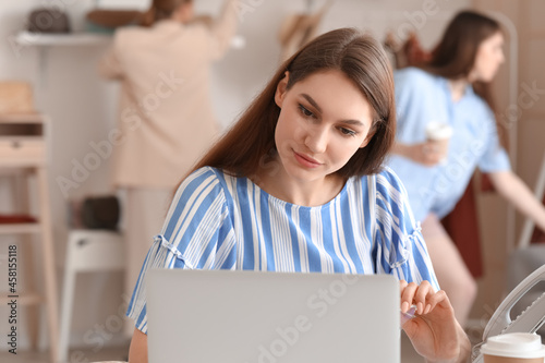 Female business owner processing order in shop
