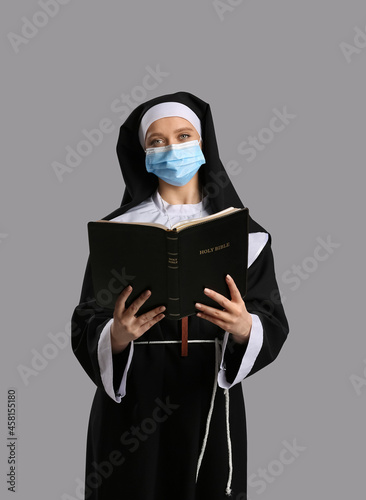 Young nun in medical mask a...
