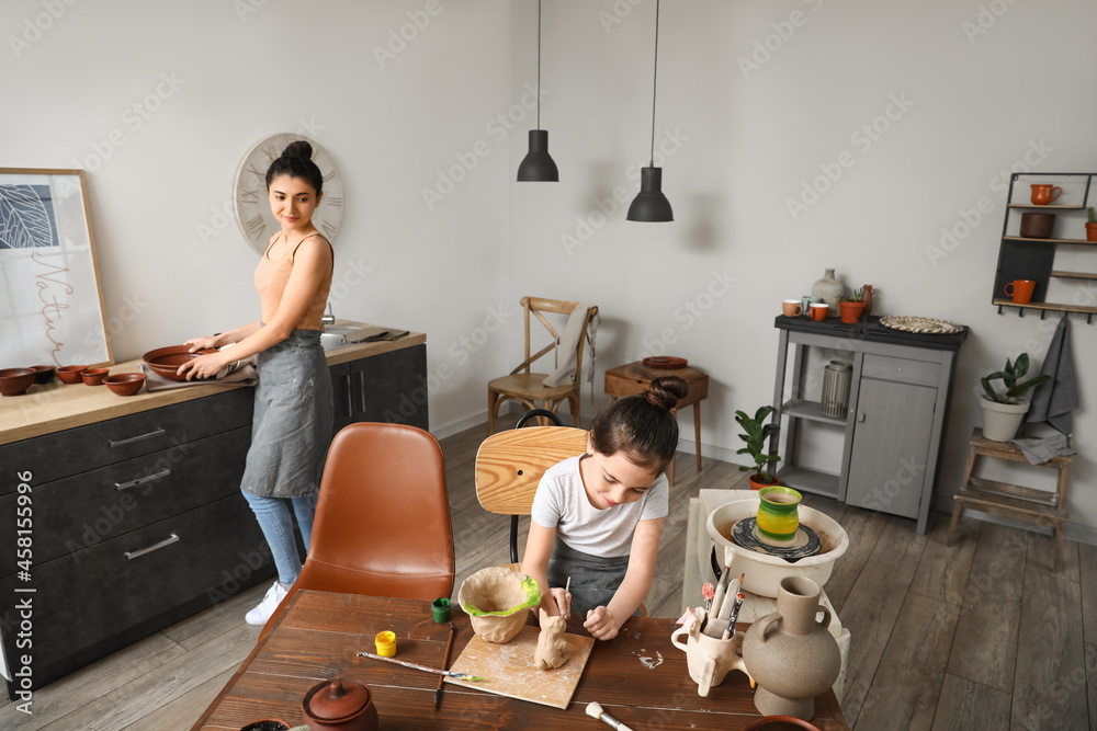 Little girl with her mother painting ceramic pot at home Stock Photo ...