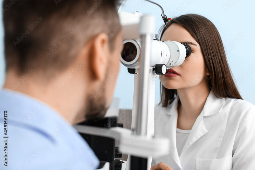 Ophthalmologist examining man in clinic