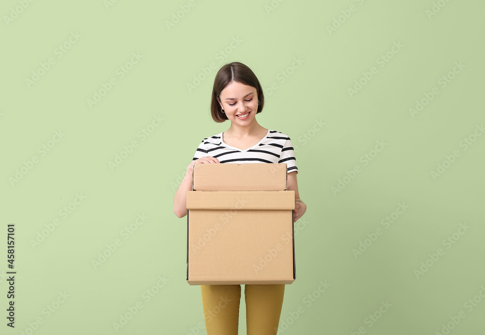 Young woman with wardrobe boxes on color background Young woman with wardrobe boxes on color background