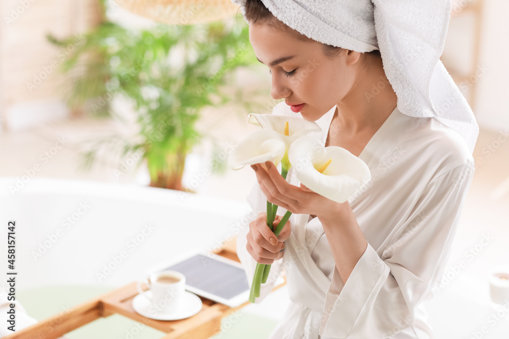 Young woman with beautiful flowers in bathroom Young woman with beautiful flowers in bathroom