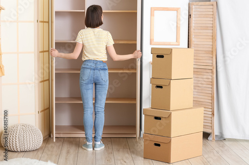 Young woman near empty wardrobe at home