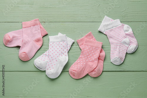 Different baby socks on color wooden background © Pixel-Shot