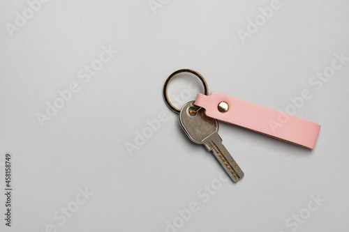 Key with leather keychain on grey background photo