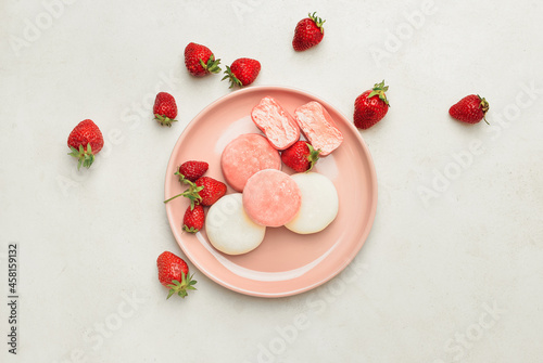 Plate with tasty Japanese mochi and strawberry on light background photo