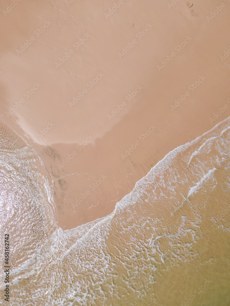 Fototapeta premium Aerial view of sandy beach and ocean with waves