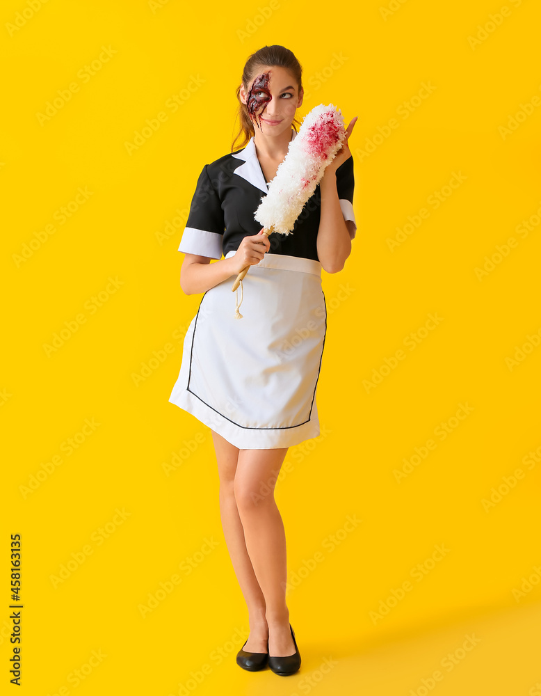 Woman dressed for Halloween as chambermaid with dust brush on color background Woman dressed for Halloween as chambermaid with dust brush on color background