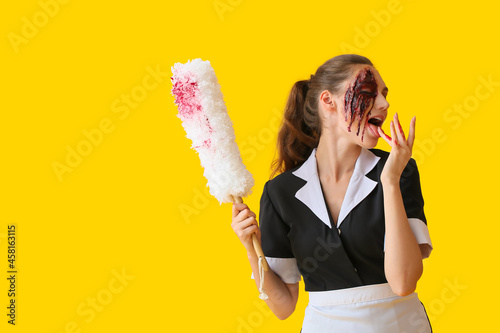 Картината върху платно Woman dressed for Halloween as chambermaid with dust brush on color background