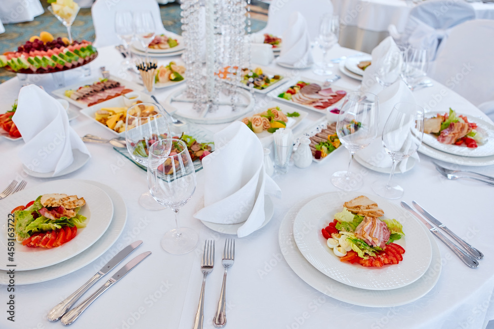 Beautifully decorated catering banquet table with different food snacks and appetizers , fresh fruits on corporate party event or wedding celebration Beautifully decorated catering banquet table with different food snacks and appetizers , fresh fruits on corporate party event or wedding celebration