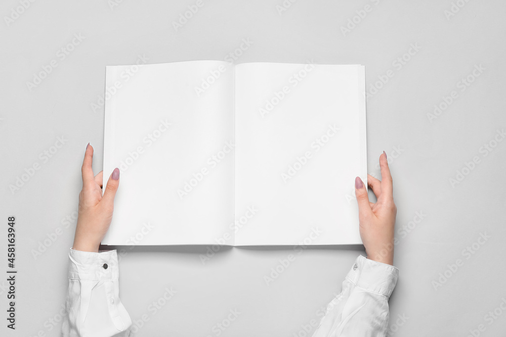 Female hands with blank magazine on light background Female hands with blank magazine on light background