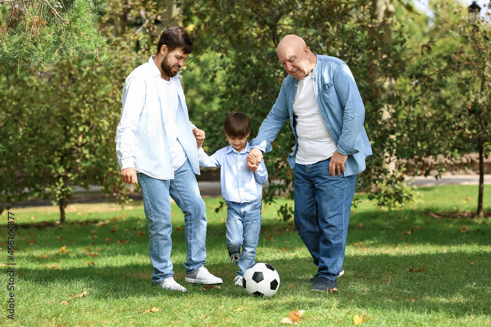 Obraz premium Man, his little son and father playing football in park