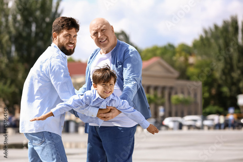 Happy man, his little son and father walking outdoors © Pixel-Shot