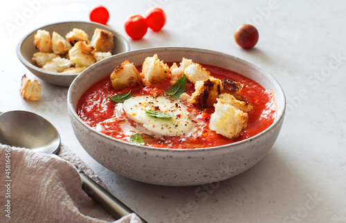 Bowl of tomato soup with mozzarella and croutons
