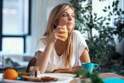 Shot of beautiful woman having healthy breakfast in the living room at home.