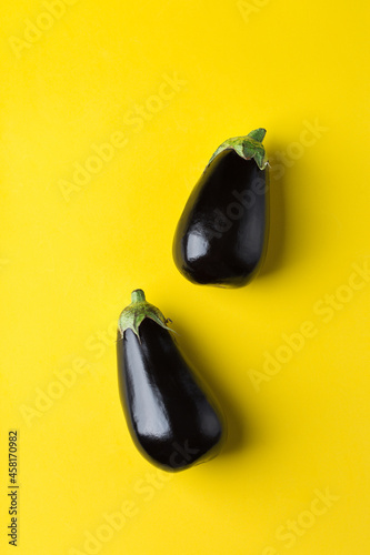 Foto Eggplant or aubergine on yellow background, healthy eating concept