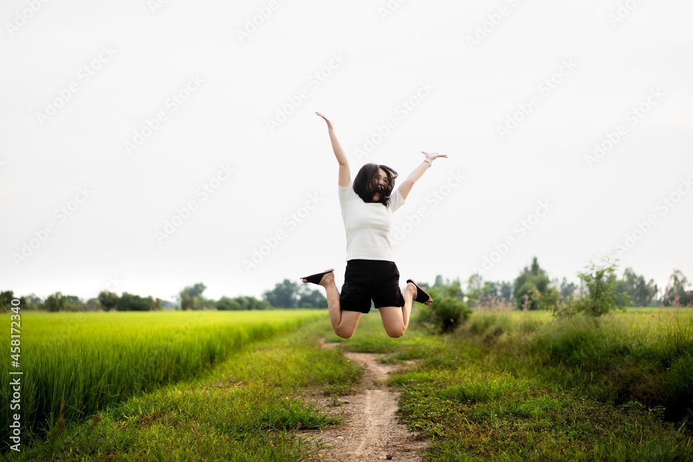 Beautiful Asian young woman enjoy running and relaxing at the rice field - meadow. Beautiful Asian young woman enjoy running and relaxing at the rice field - meadow.