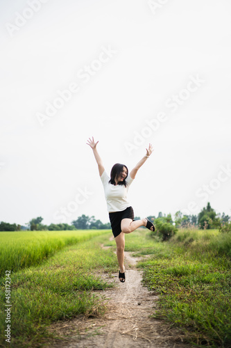 Beautiful Asian young woman enjoy running and relaxing at the rice field - meadow. 