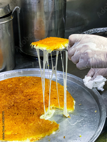 Preparation of Knafeh or Kanafeh, a traditional Middle Eastern dessert photo