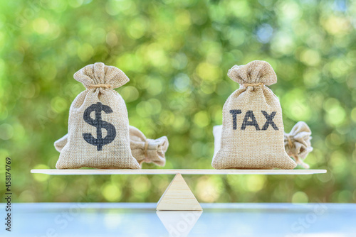 Income tax collection, strategy for paying tax, financial concept : Tax, dollar money bags on a simple / basic balance scale, depicts planning for reducing tax liability e.g investment and retirement