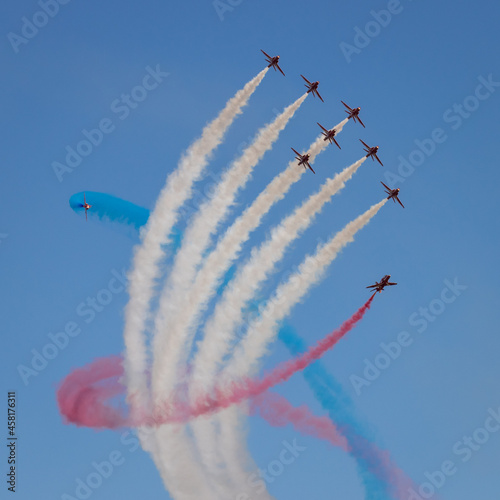 Team of jet-lanes display on blue sky