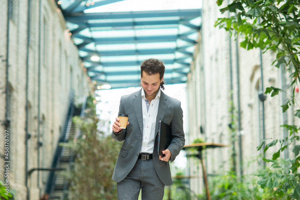 A young successful businessman is walking down the street. Man in a casual wear. Business, freelance and remote work. A young successful businessman is walking down the street. Man in a casual wear. Business, freelance and remote work.