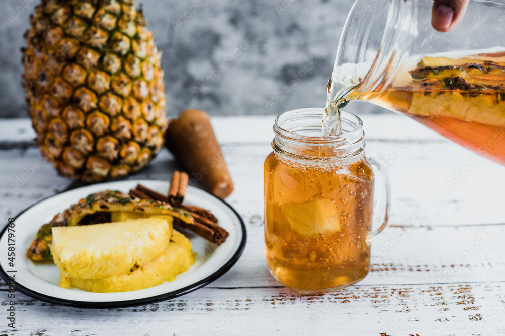 Tepache mexican Fermented pineapple drink and hand holding a Jar with ...