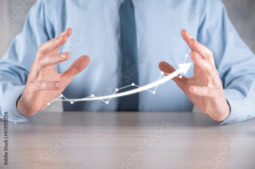 Businessman hold drawing on screen growing graph  arrow of positive growth icon.pointing at creative business chart with upward arrows.Financial  business growth concept.