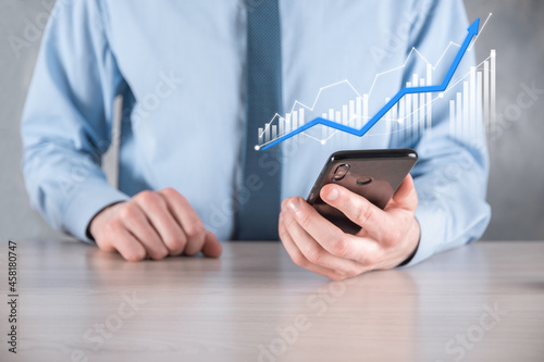Fototapeta Naklejka Na Ścianę i Meble -  Businessman man holding a graph with positive profits growth. plan graph growth and increase of chart positive indicators in his business.more profitable and growing