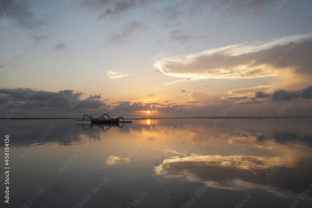 Beautiful morning, very calm, with reflection of sky on the water. Sanur Beach, Denpasar City, Bali Province, Indonesia